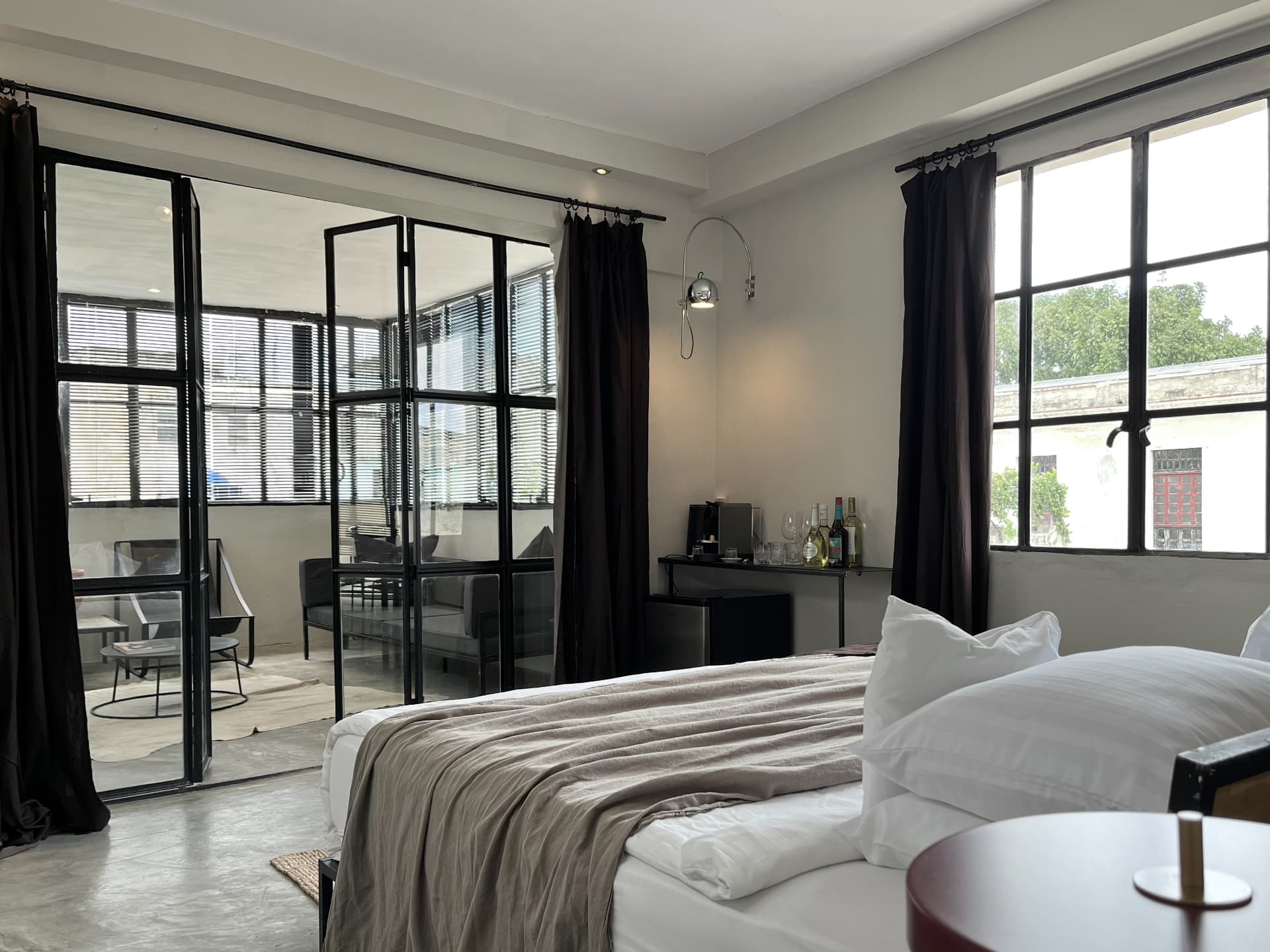 Sunlit private guesthouse suite in Cuba with steel-framed windows and a balcony sitting area